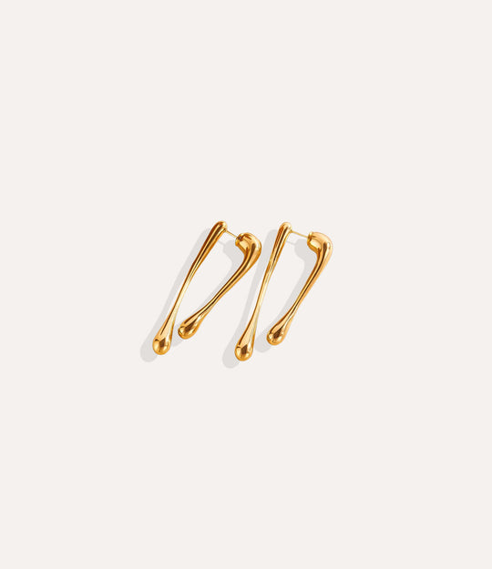 Close up of The Drip Earrings in gold showing the smooth drip shape and 18k gold plating.
