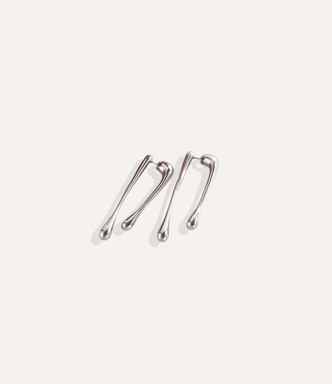 Close up of The Drip Earrings in silver featuring the polished drip-inspired design.