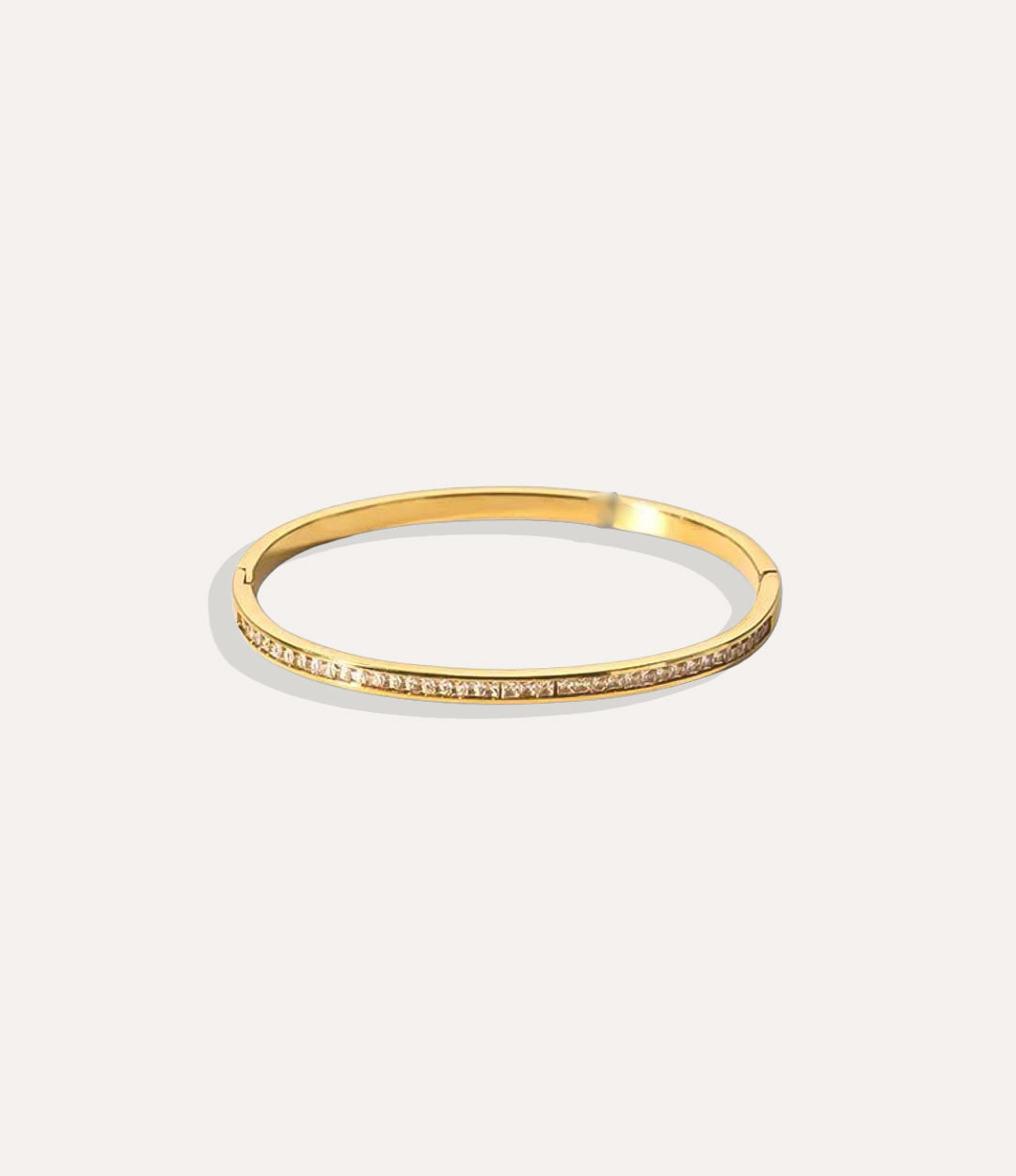 The Duchess Bangle in 18k gold plated stainless steel displayed on a neutral background.”