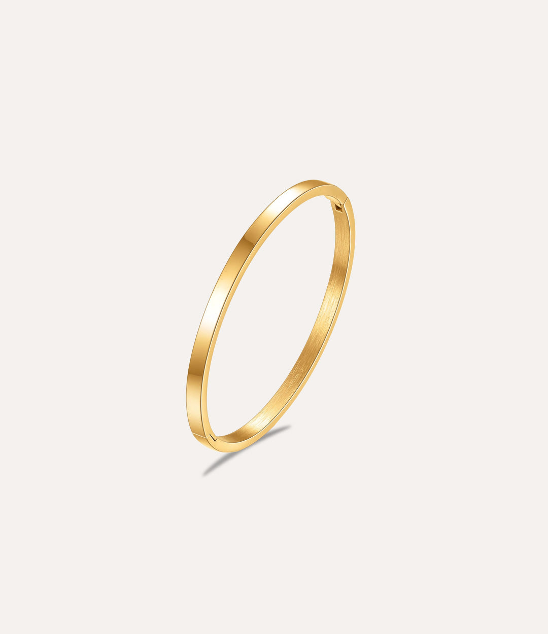 The Essential Bangle in gold titanium steel displayed on a clean white background