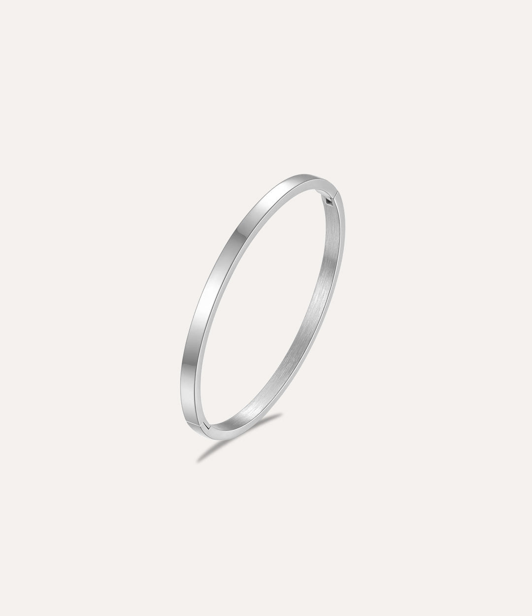 The Essential Bangle in titanium steel displayed on a clean white background