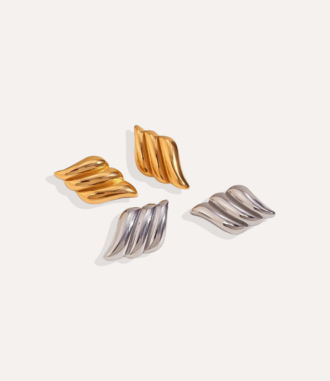 Product shot of The Griselda Earring in 18k gold plating and silver displaying the unique wing like design and high shine finish on a white background.