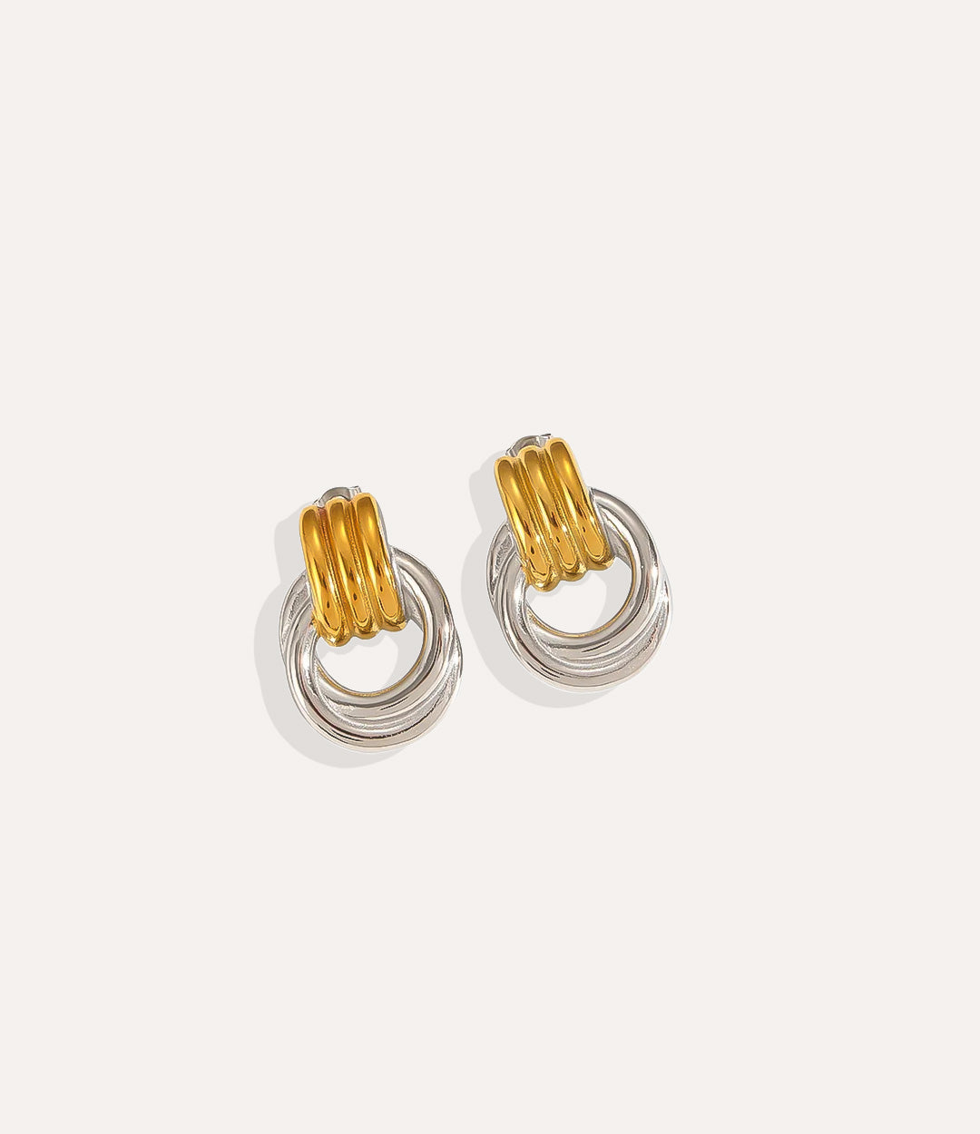 Product shot of The Knot Earring in silver and gold colours showing the cool stainless steel finish and durable construction on a white background.