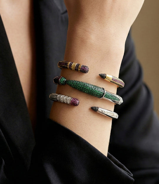 Close-up of a wrist wearing multiple colorful bracelets on a neutral background