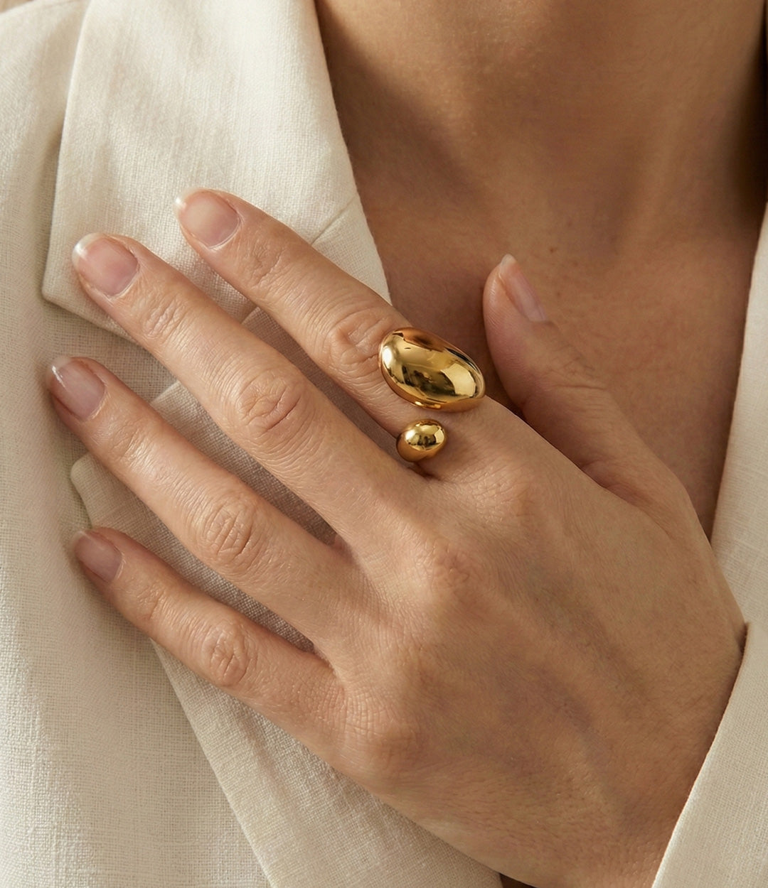 Gold ring on a hand with a neutral background