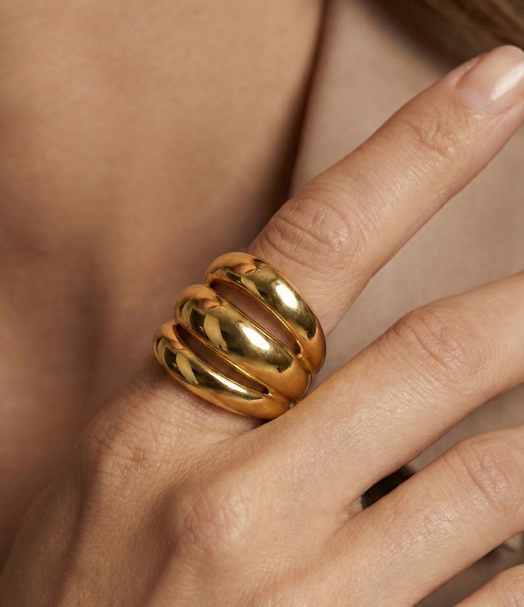 Woman's hand modelling the Triple Stack Ring on the pointer finger, showcasing the elegant illusion of three stacked bands and the sophisticated finish.