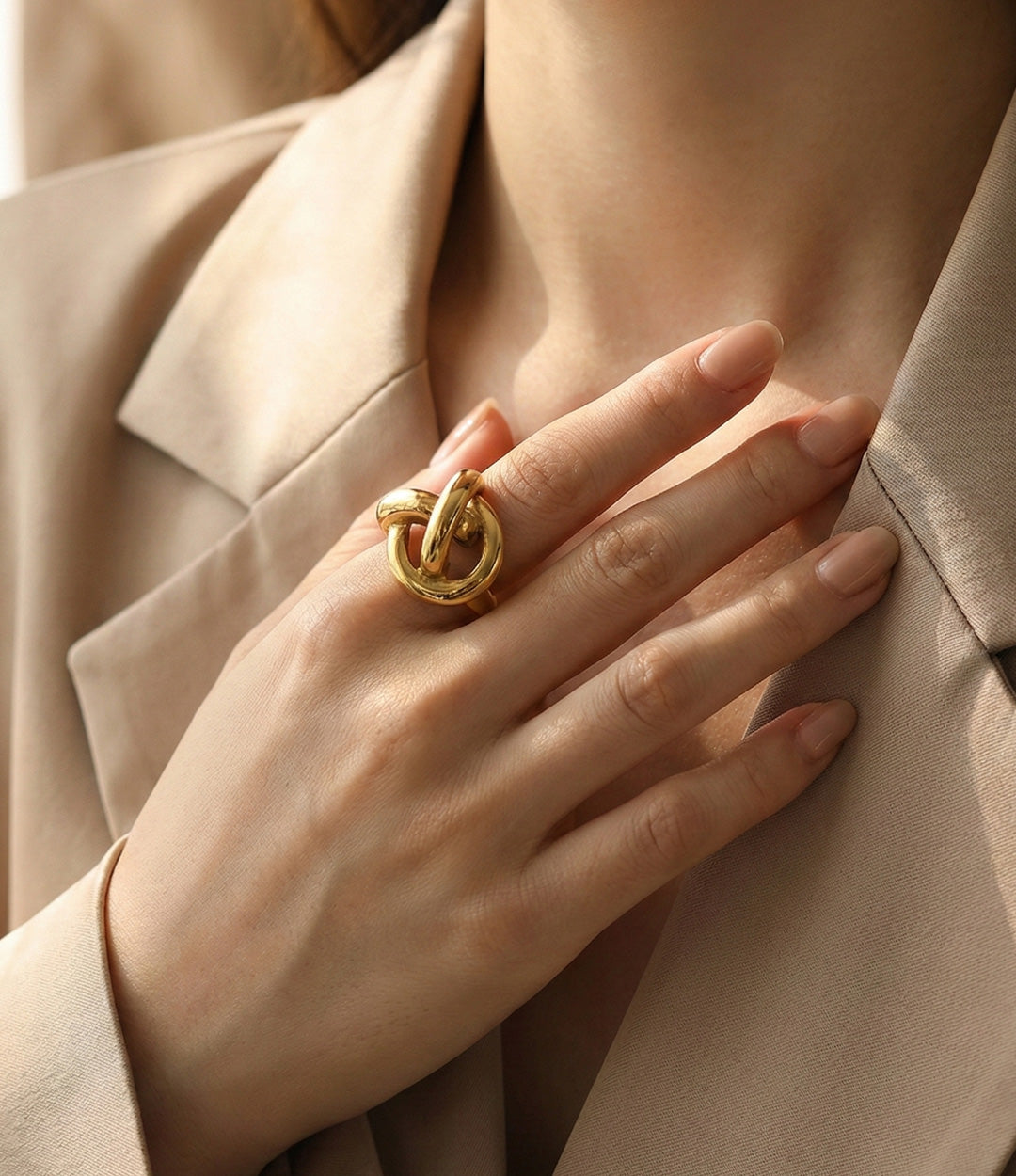 Gold ring on a hand with a neutral background