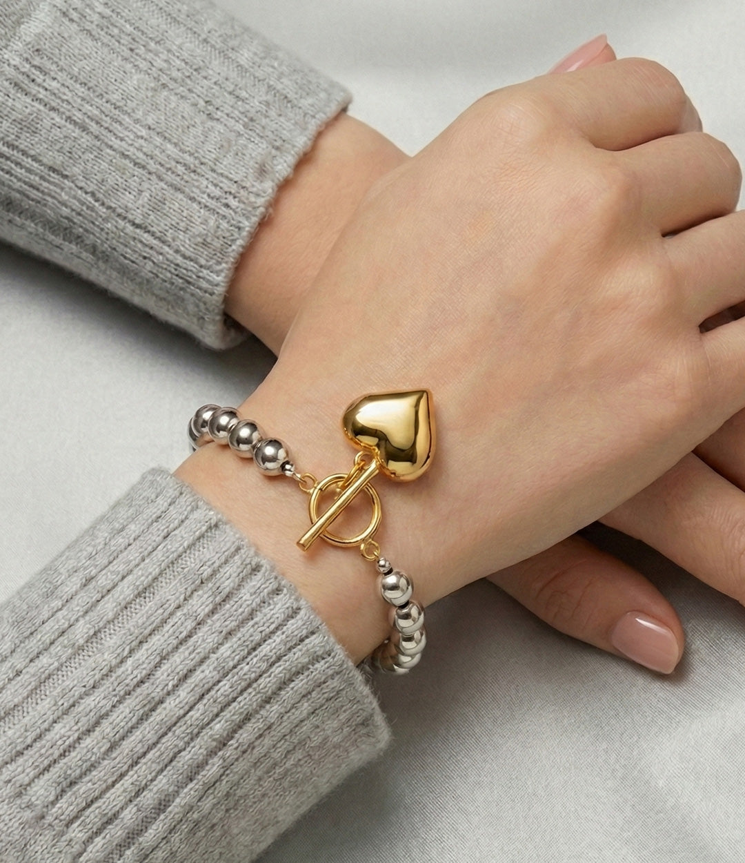 Model wearing the Two-Tone Heart Bracelet, paired with the Two-Tone Heart Necklace.