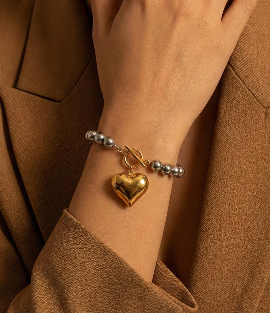 Model wearing the Two-Tone Heart Bracelet, paired with the Two-Tone Heart Necklace.
