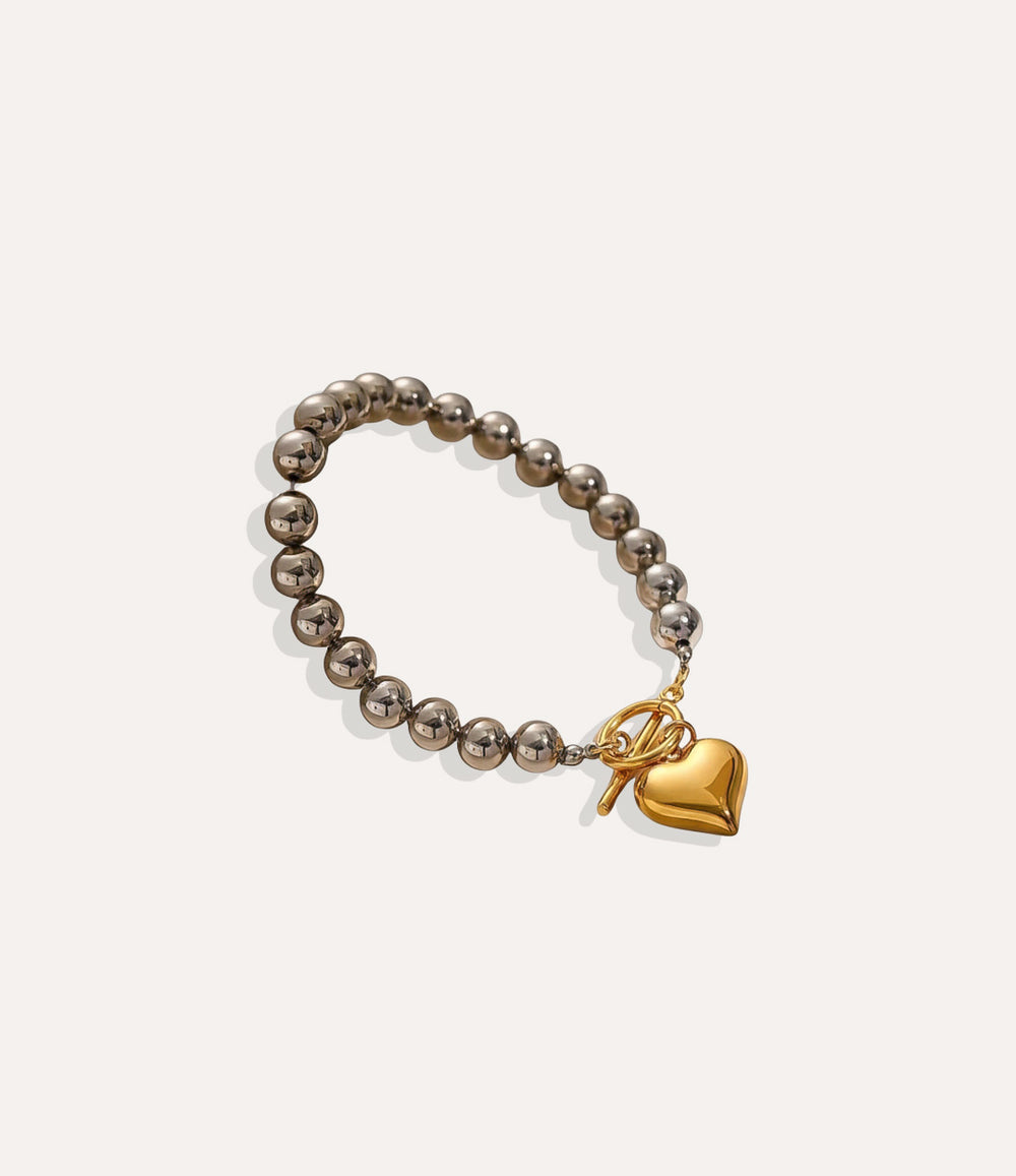 Two-Tone Heart Bracelet with chunky gold and silver links and heart charm displayed on a neutral background.