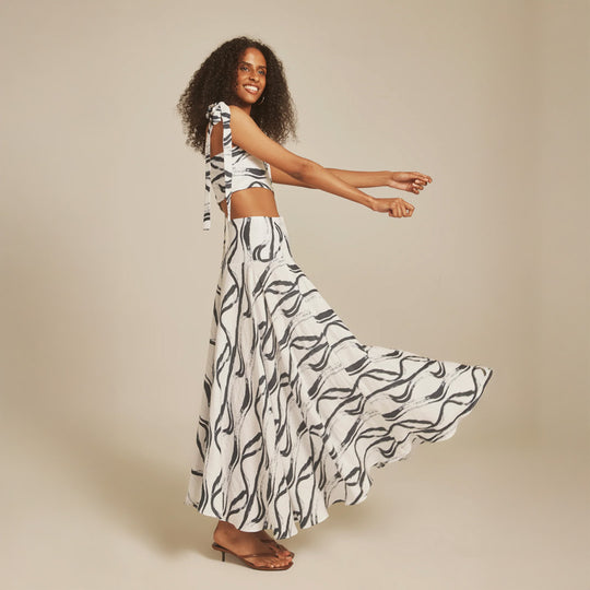 Woman wearing a black and white patterned outfit on a beige background