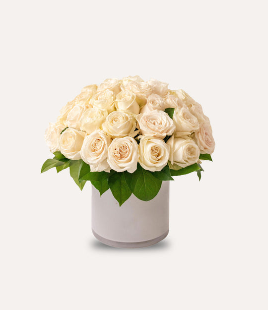 Bouquet of white roses in a white vase on a light gray background